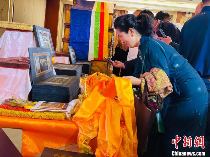 圖為現(xiàn)場藏族民眾向黃金書寫的大藏經(jīng)《甘珠爾》敬獻(xiàn)哈達(dá)?！O睿 攝