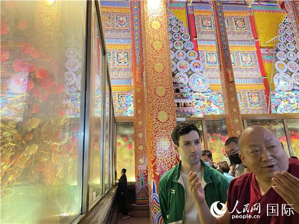 7月25日，省級非物質(zhì)文化遺產(chǎn)項目塔爾寺酥油花的代表性傳承人朋措堅參（右）在塔爾寺酥油花館講解酥油花的制作過程。人民網(wǎng) 謝瑩攝