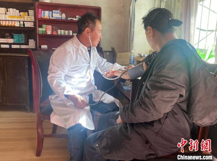 索木滾(左)為村民看病?！∪捞量h委宣傳部供圖