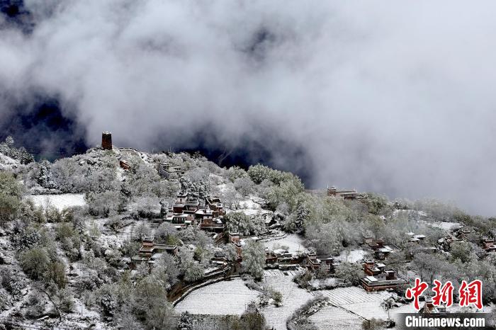 雪后的藏寨和碉樓構(gòu)成美麗的雪景?！〗党鯘衫?攝