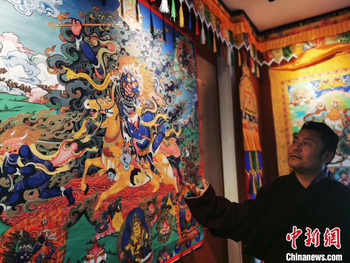 圖為久美尖措展示唐卡作品。　張?zhí)砀?攝