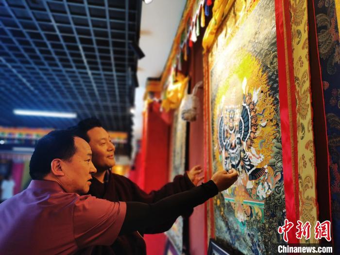 圖為久美尖措展示唐卡作品。　張?zhí)砀?攝