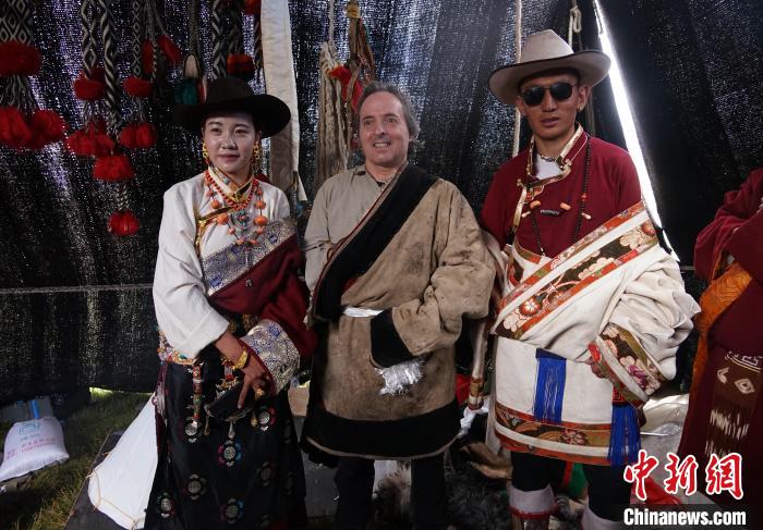 圖為一名外籍攝影師(中)身穿藏服和藏族民眾合影留念?！●R銘言 攝