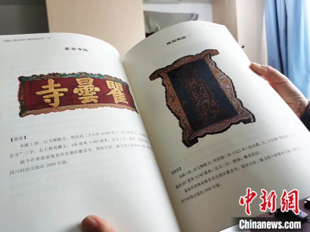 古籍保護(hù)人員展示介紹明代朱元璋撰寫的青海瞿曇寺匾(左)的出版書籍。張?zhí)砀?攝