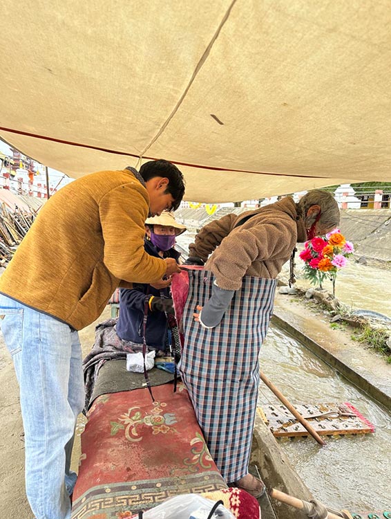 扎西奪爾登為路邊老人送去保暖圍腰。阿壩州文明辦供圖