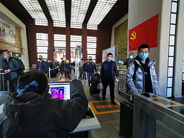 拉薩火車站工作人員對出站旅客進行紅外線測溫。趙越拍攝.jpg