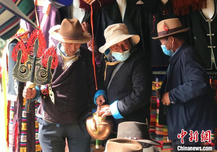 圖為三位藏族老人在集市上聊天交談?！∪轿木?攝