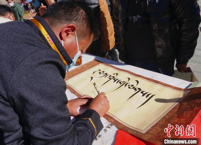 圖為書(shū)法家展示藏文書(shū)法?！∪轿木?攝