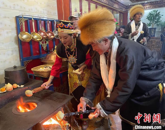圖為人們在火上烤節(jié)日美食“結(jié)達(dá)”。　冉文娟 攝