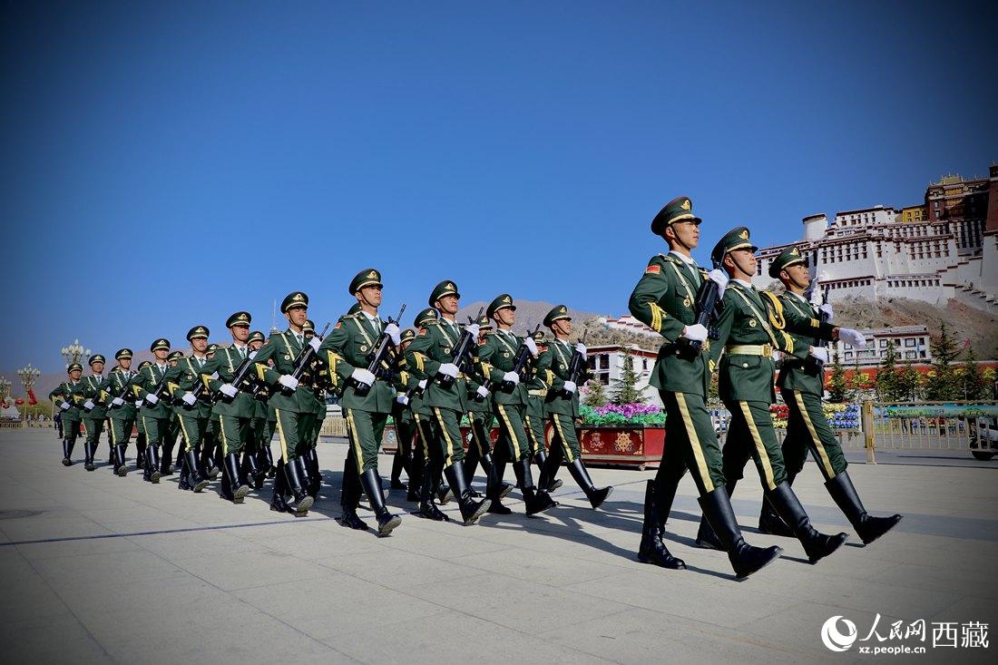 國旗護衛(wèi)隊隊員緊握鋼槍，踏著威武雄壯的步伐，走向國旗臺。人民網(wǎng) 次仁羅布攝