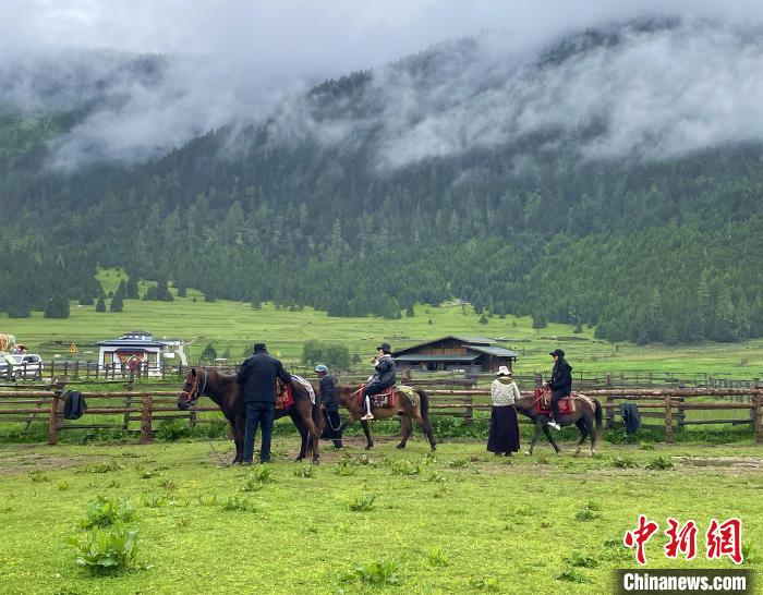 6月10日，游客在魯朗小鎮(zhèn)高山牧場(chǎng)景區(qū)體驗(yàn)騎馬?！∪轿木?攝