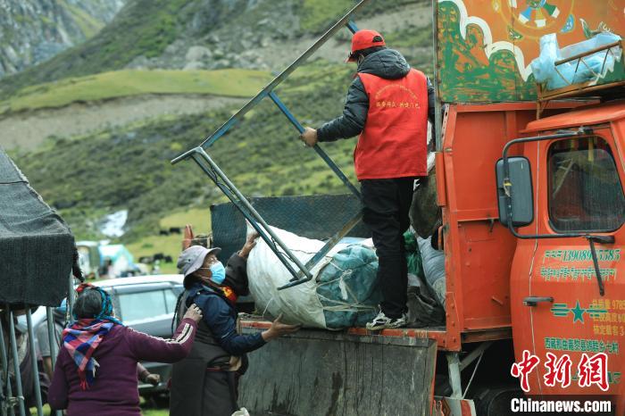 圖為工作人員幫助牧民們卸家具?！÷蹇?攝