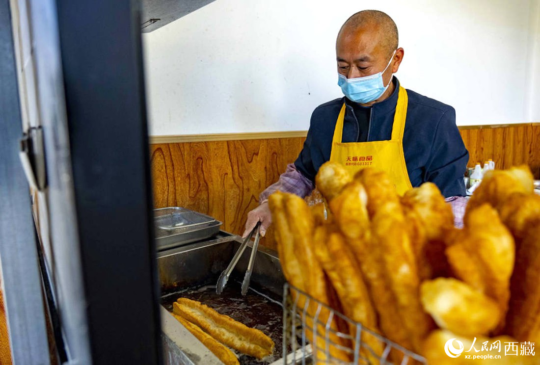 早餐店老板正在炸油條。人民網(wǎng) 次仁羅布攝
