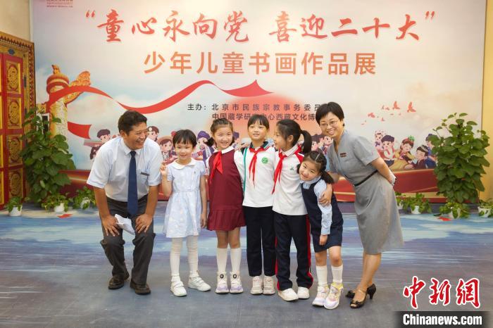 圖為與會嘉賓與入選畫作的“小作者”們在展覽上合影?！≈袊貙W(xué)研究中心供圖