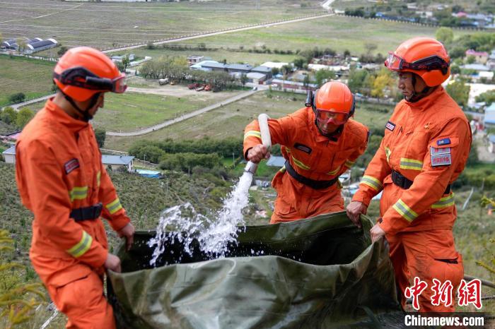 技能大練兵過程中，消防員在陡坡上向蓄水池注水。　李國(guó)燾 攝