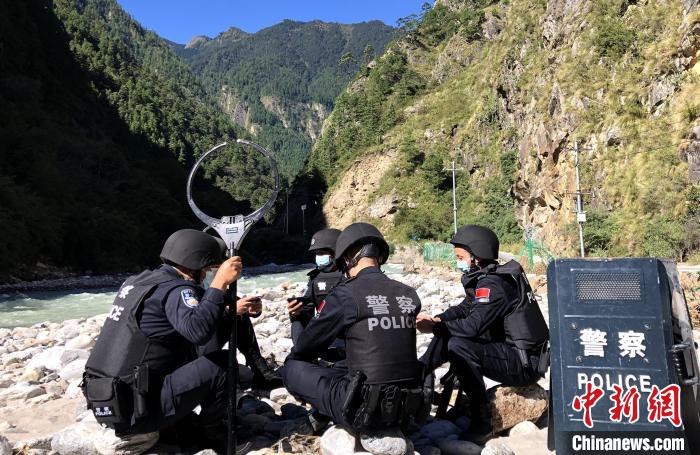 圖為西藏吉隆出入境邊防檢查站移民管理警察在中尼邊境巡邏途中收看二十大開幕直播。　郭章統(tǒng) 攝