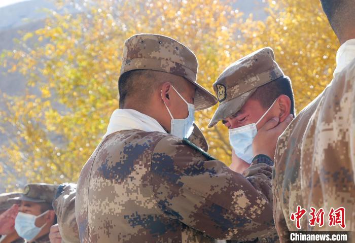圖為什布奇邊防連退伍老兵與戰(zhàn)友相擁而泣，依依惜別?！⌒觳?攝