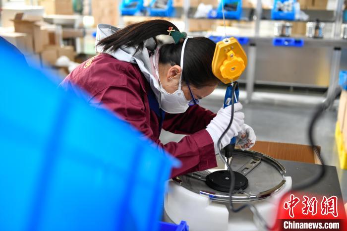 圖為工人正在組裝炊具?！∝暩聛硭?攝