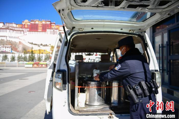 圖為1月23日，布達(dá)拉宮廣場(chǎng)派出所民警正在打午飯?！∝暩聛硭?攝