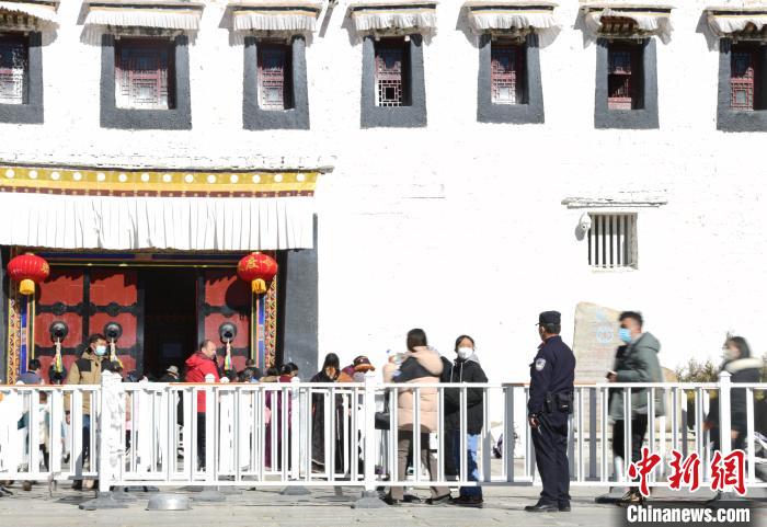圖為1月23日，布達(dá)拉宮廣場(chǎng)派出所民警正在引導(dǎo)游客?！∝暩聛硭?攝