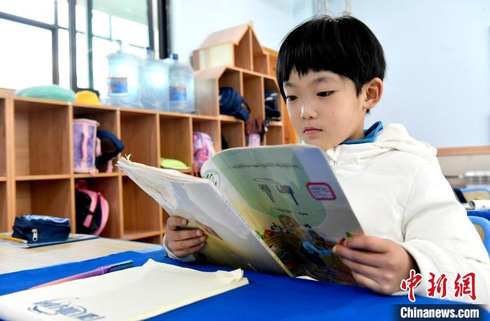 3月14日，西藏拉薩市第一小學(xué)一年級六班學(xué)生丁增樂吉在閱讀藏語課本?！±盍?攝