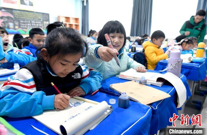 3月14日，西藏拉薩市第一小學(xué)一年級六班學(xué)生白瑪朗珍(圖左)在藏語文課上書寫藏文?！±盍?攝