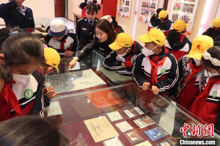 圖為亞東邊檢站民警為駐地小學生講解該站榮譽發(fā)展史。　胡利媛 攝