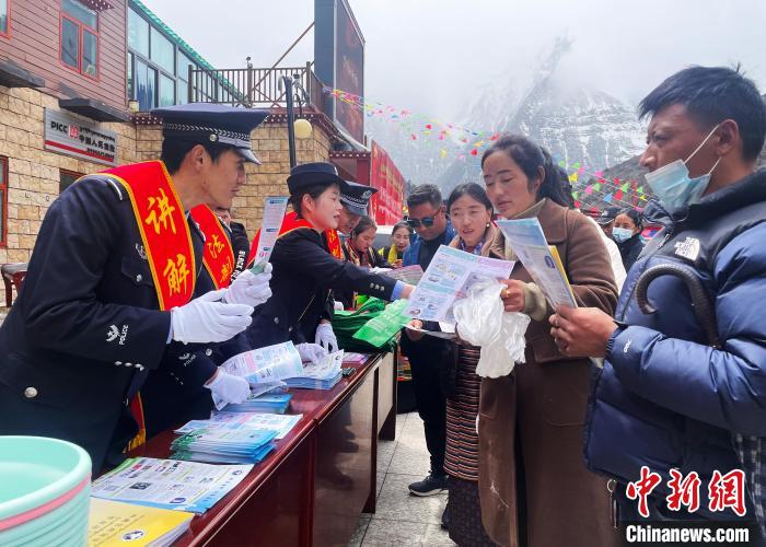 圖為山南玉麥邊境派出所民警為轄區(qū)群眾發(fā)放法律知識(shí)宣傳單?！＄婗?　攝