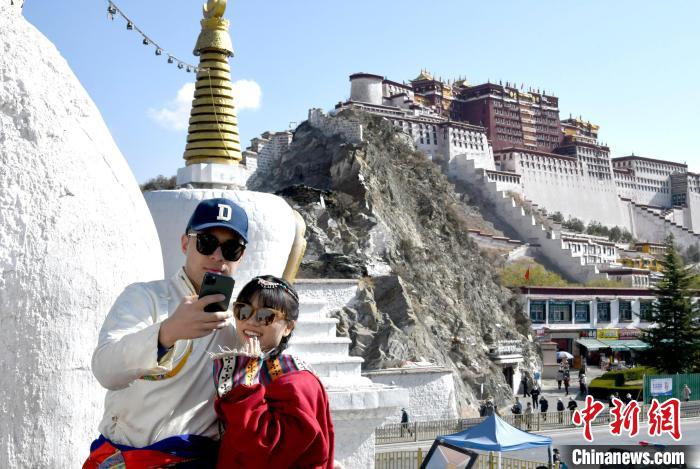 4月17日，游客身著藏式元素服裝在拉薩布達(dá)拉宮觀景臺(tái)拍照留念?！±盍?攝