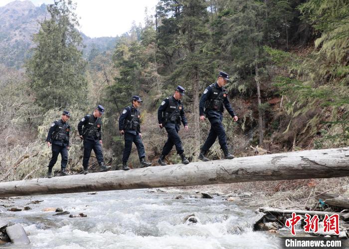 山南邊境管理支隊玉麥邊境派出所民警邊境巡邏途中走過河道上“獨木橋”。　鄭琦山 攝