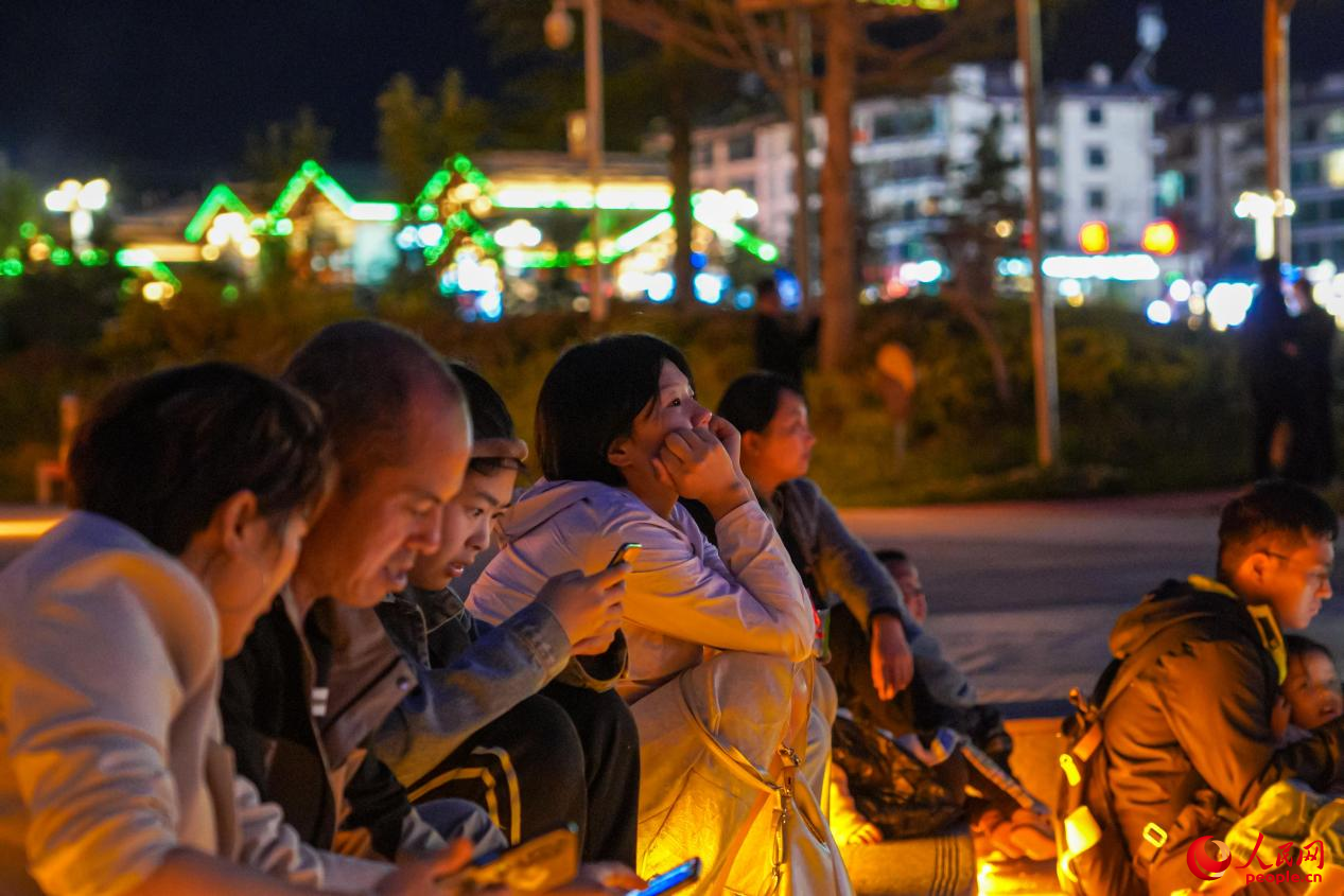 市民坐在西藏林芝市民族團結(jié)廣場臺階上欣賞音樂噴泉。人民網(wǎng)記者 趙晨攝